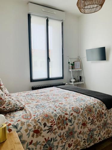 - une chambre avec un lit doté d'un couvre-lit floral et d'une fenêtre dans l'établissement Perne, chambre d'hôtes à la campagne, à Frossay