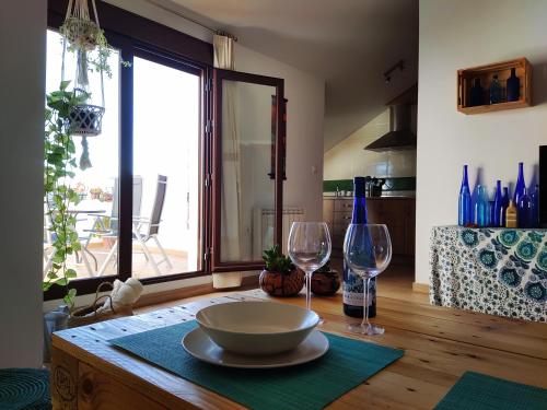 a table with a bowl and two wine glasses on it at El Ático de La Casa Viva in Vélez Blanco