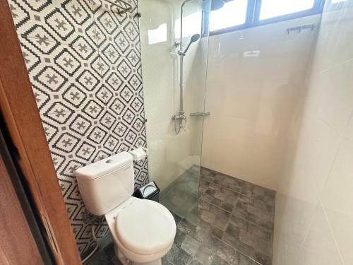 a small bathroom with a toilet and a shower at Naeera Guest House in Ubud