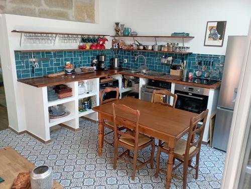 een keuken met een houten tafel en een keuken met blauwe tegels bij Duplex La Terrasse Jasmin in Mèze