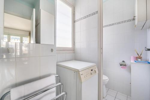 une salle de bains blanche avec un lave-linge et une fenêtre. dans l'établissement A056 - Nice Studio Cannes centre with parking, à Cannes