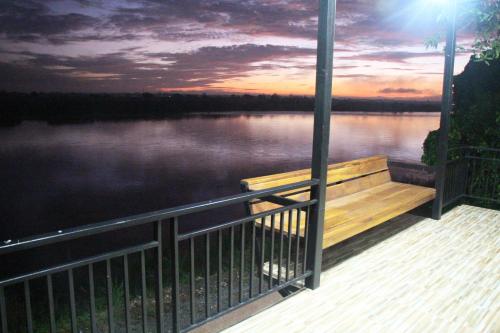 a bench on a dock with a view of a lake at Mekong Tarawadee Villa in Tha Bo