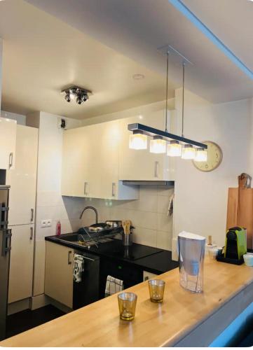 une cuisine avec un comptoir en bois dans une pièce dans l'établissement Nice cozy flat near Paris, à Puteaux