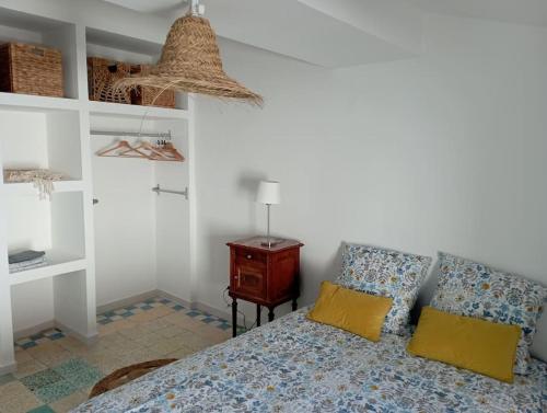 - une chambre avec un lit doté d'oreillers jaunes et d'une table dans l'établissement Duplex La Terrasse Jasmin, à Mèze
