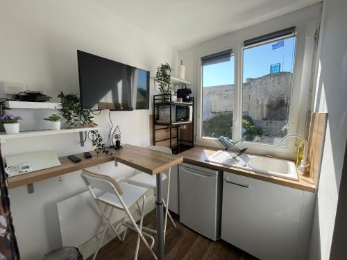 une cuisine avec un bureau, un évier et une fenêtre dans l'établissement Castle - Vue sur le château - Hypercentre, à Caen