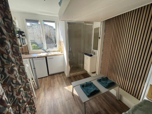 La salle de bains est pourvue d'une douche et d'une table dans la chambre. dans l'établissement Castle - Vue sur le château - Hypercentre, à Caen