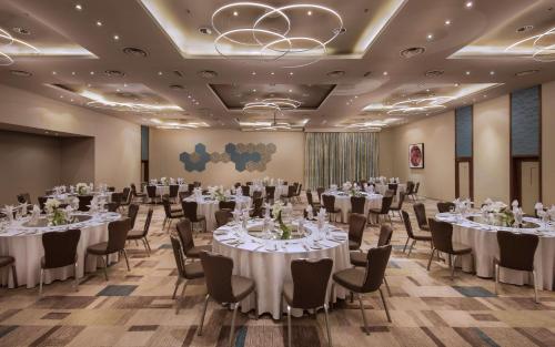 a ballroom with tables and chairs with white tablecloths at Hennessy Park Hotel in Ebene