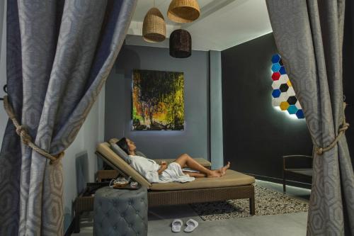 a man laying on a couch with a baby at Hennessy Park Hotel in Ebene