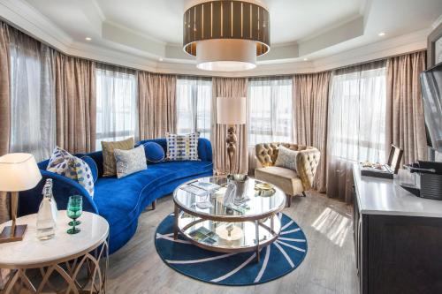 a living room with a blue couch and a table at Labourdonnais Waterfront Hotel in Port Louis