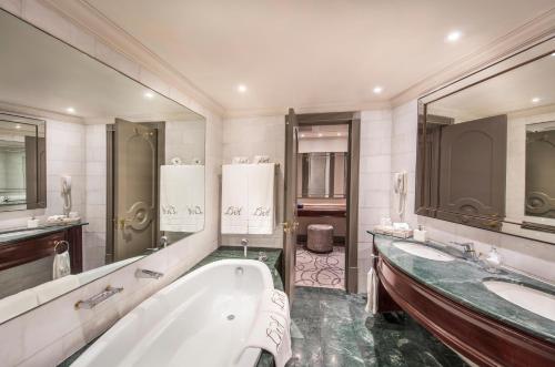 a bathroom with two sinks and a bath tub at Labourdonnais Waterfront Hotel in Port Louis