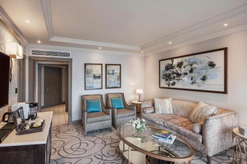 a living room with a couch and a table and chairs at Labourdonnais Waterfront Hotel in Port Louis