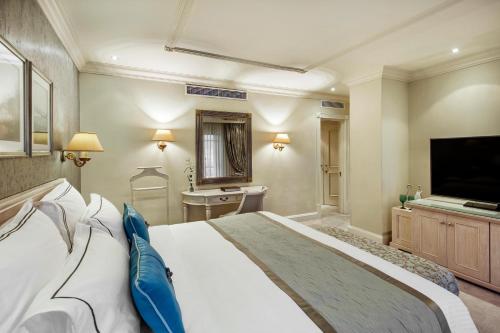 a bedroom with a large bed and a flat screen tv at Labourdonnais Waterfront Hotel in Port Louis