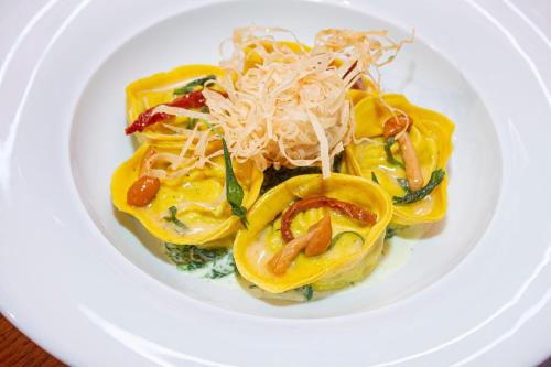 a plate of food with pasta on a white plate at Hennessy Park Hotel in Ebene