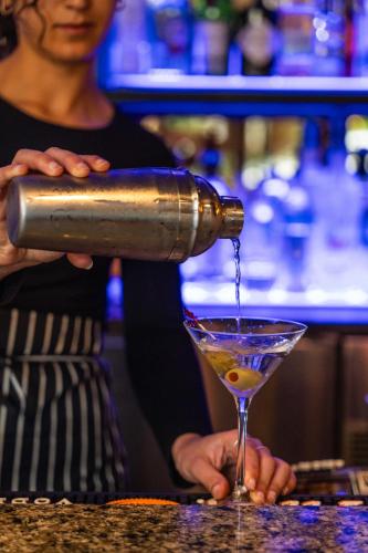 a bartender making a drink in a martini glass at The River Inn in Washington