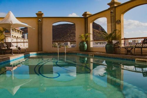 a pool at a hotel with a view of the mountains at Labourdonnais Waterfront Hotel in Port Louis