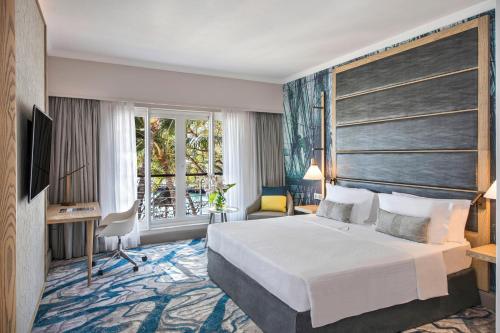a hotel room with a bed and a large window at Le Suffren Hotel & Marina in Port Louis