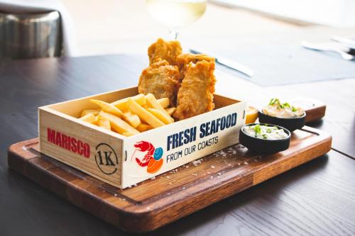 a tray of fried chicken and french fries on a table at Le Suffren Hotel & Marina in Port Louis