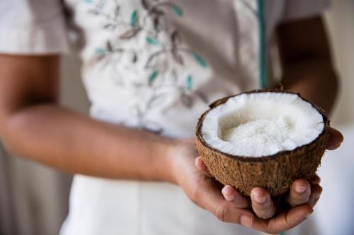a person holding a coconut in their hands at Le Suffren Hotel & Marina in Port Louis