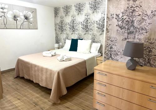 a bedroom with a bed and a dresser with towels on it at Case vacanze ''Estremo Sud'' Lampedusa in Lampedusa