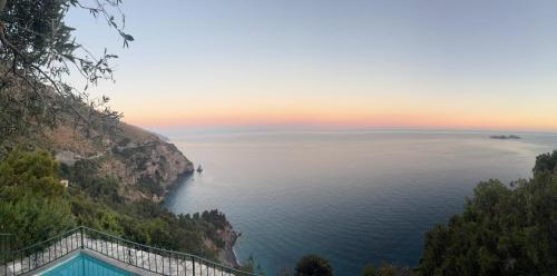 a view of the amalfi coast at sunset at Seacliff Heaven - De Vivo Realty Positano in Arola