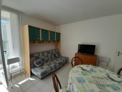 un salon avec une table et un canapé dans l'établissement Studio cosy avec jardin, proche plage et commerces - FR-1-324A-5, à Saint-Hilaire-de-Riez