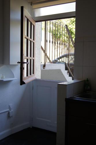 une cuisine avec une fenêtre avec un évier et des escaliers dans l'établissement Studio Albigny A 200 m du lac d'Annecy, à Annecy