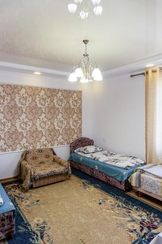 a bedroom with two beds and a chandelier at Guest house and yurt camp Svetlana in Bokonbayevo