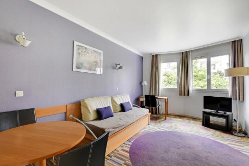 ein Wohnzimmer mit Sofa und Tisch in der Unterkunft GuestReady - Apt moderne Paris La Défense avec AC in La Défense