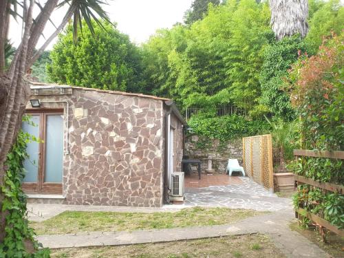 a small stone building with a patio in a garden at Vacation Home Tuscany Pisa-Lucca Studio apartment in Vecchiano