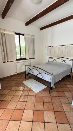 a bedroom with a bed and a tiled floor at Villa Canu in Alghero
