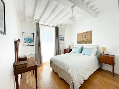 une chambre blanche avec un lit et une table dans l'établissement Le 58 Bayeux bel apt bien équipé centre ville parking gratuit à proximité, à Bayeux