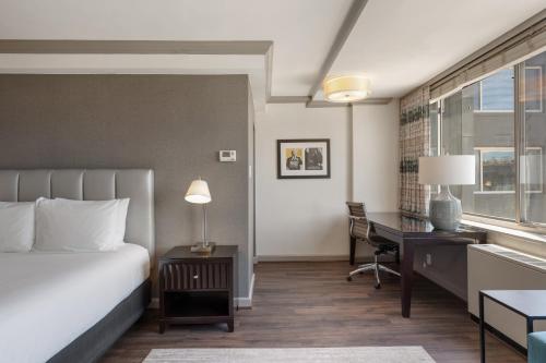 a hotel room with a bed and a desk and a window at The River Inn in Washington