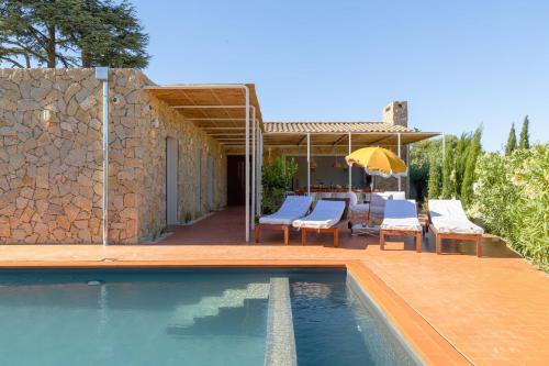 une villa avec une piscine à côté d'un mur en pierre dans l'établissement Villa St Remy Centre Piscine chauffée et Hammam, à Saint-Rémy-de-Provence
