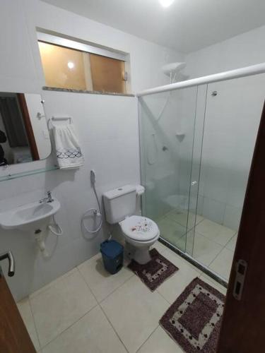 a bathroom with a toilet and a sink and a shower at Pérola Rosa 04 in Ilhéus