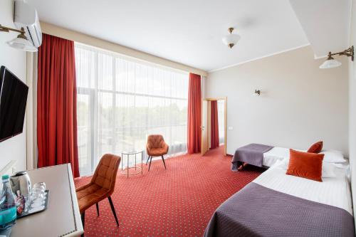 a hotel room with two beds and a window at Europa Royale Druskininkai in Druskininkai