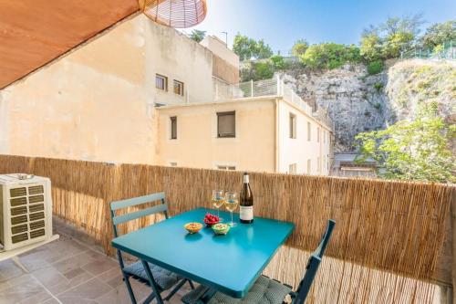 - une table bleue avec une bouteille de vin sur un balcon dans l'établissement Divine Idylle Central Vieux-Port Terrasse Clim, à Marseille