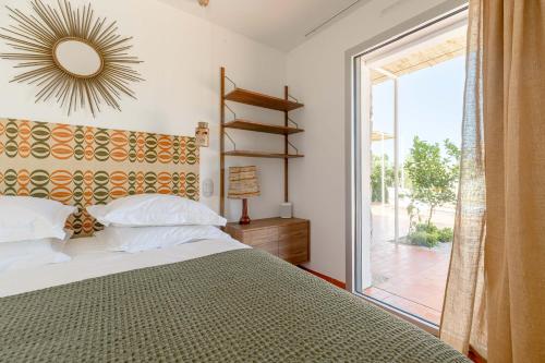 a bedroom with a bed and a large window at Villa St Remy Centre Piscine chauffée et Hammam in Saint-Rémy-de-Provence