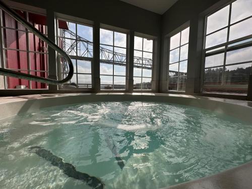 a large bath tub in a room with windows at Cannery Pier Hotel & Spa in Astoria, Oregon