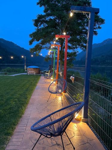 a park bench with lights on it at night at Complex Brădișor in Malaia