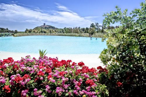 a bunch of flowers in front of a body of water at Veridia Resort Sardinia, a member of Radisson Individuals in Chia
