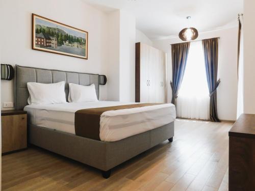 a bedroom with a large bed and a window at Casa Oliva Villa A with heating pool in Budva