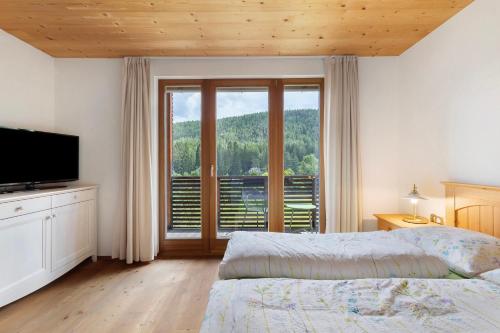 a bedroom with a bed and a large window at Silbernagl - Monolokal mit Ausblick in Issengo