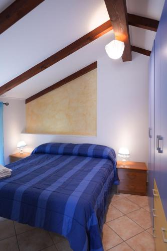 a bedroom with a blue bed in a room at Casa Vacanza Gialu in Erchie