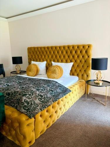 a bedroom with a large yellow bed with two tables at Schloss Kartzow in Potsdam