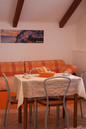 a dining room table with chairs and a couch at Casa Vacanza Gialu in Erchie