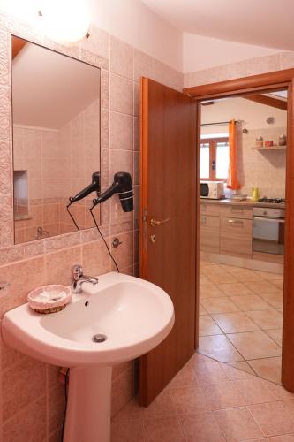 a bathroom with a sink and a mirror at Casa Vacanza Gialu in Erchie