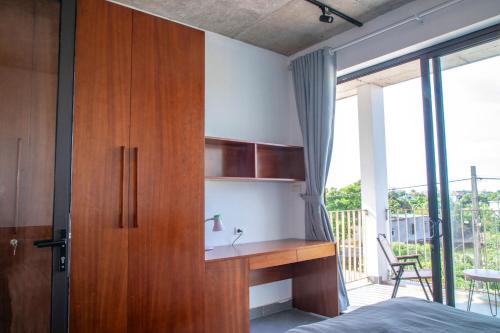 a bedroom with a wooden cabinet and a desk at CRIN HOUSE Đồng Châu in Lạc Thành