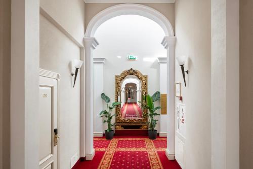 a hallway with an archway and a red carpet at Europa Royale Druskininkai in Druskininkai