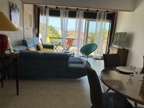 un salon avec un canapé et une table dans l'établissement Maison 4 pièces, 5 pers, climatisation, terrasse, 450m plage, animaux admis - FR-1-229D-128, à Fleury