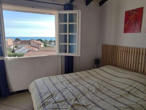une chambre avec un lit et une grande fenêtre dans l'établissement Maison 4 pièces, 5 pers, climatisation, terrasse, 450m plage, animaux admis - FR-1-229D-128, à Fleury